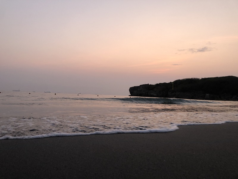 A black sand beach with pink skies on Cijin Island