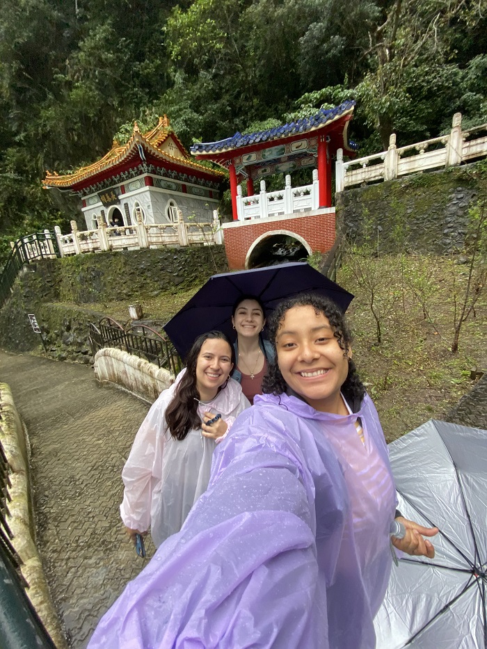 A CET Taiwan student and two of her friends holding umbrellas and wearing ponchos while exploring the outdoors of Taroko Gorge in Taiwan