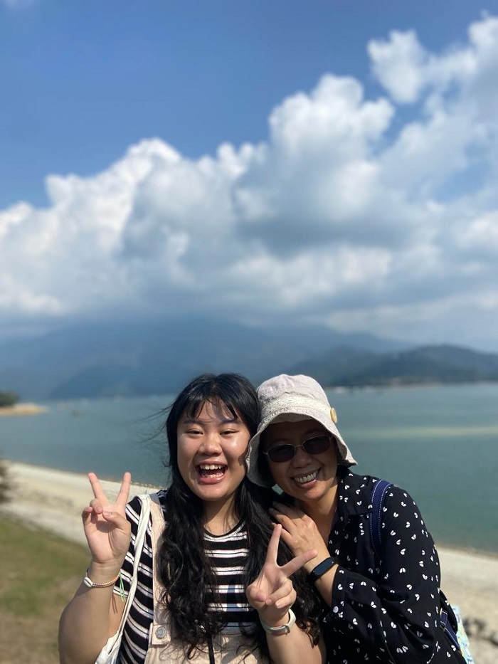 A mother and her daughter smiling in front of a large body of water in Taiwan