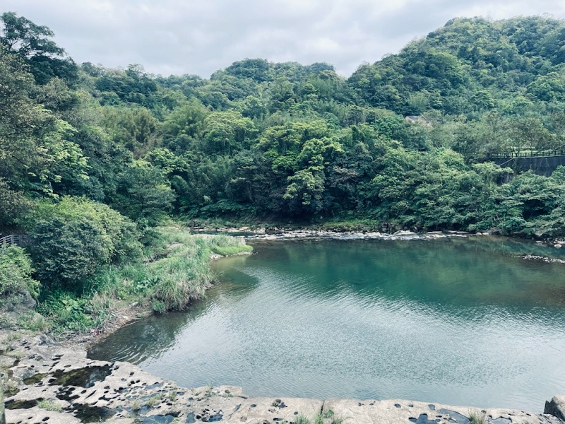 A large pond surrounded by green trees in Shifen District in Taiwan
