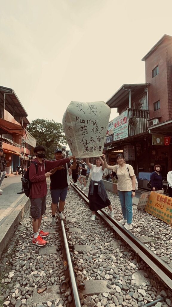 CET Taiwan students and Taiwanese language partners holding up a decorated paper lantern to be lifted into the sky outside