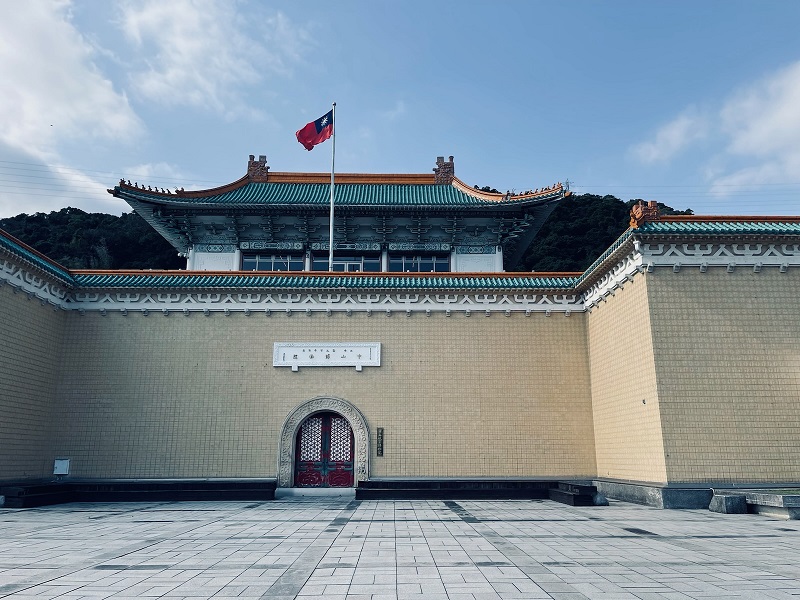 A side of the National Palace Museum building and the flag of Taiwan waving in the center