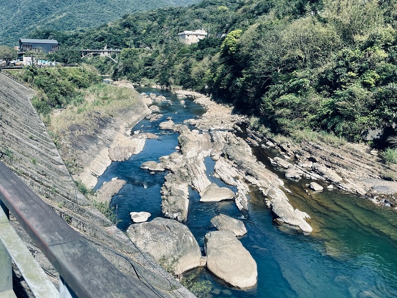 A river with many large rocks separating the body of water near Houtong Cat Village in Taiwan