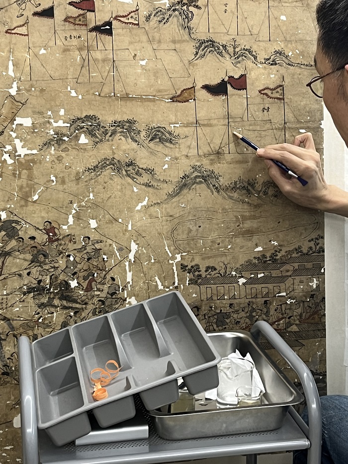 Someone restoring art on a painting at an art restoration studio in Taiwan