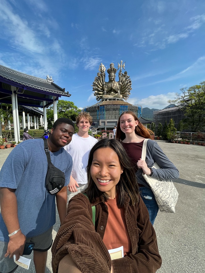 CET Taiwan students taking a selfie and smiling in front of the Yuan-Dao Guanyin Temple in Tamsui