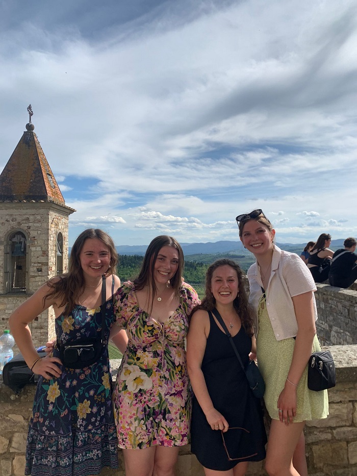 Four female CET Florence students smiling while on top of a castle in the Tuscan hills