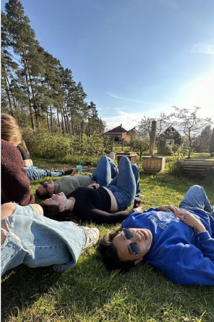 A group of CET Prague students laying on the grass and enjoying the sun outdoors