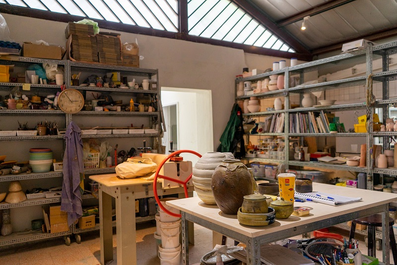 The indoor studio of a pottery shop called Cloud Forest Collective in Taiwan with many art supplies, clay pots, and more