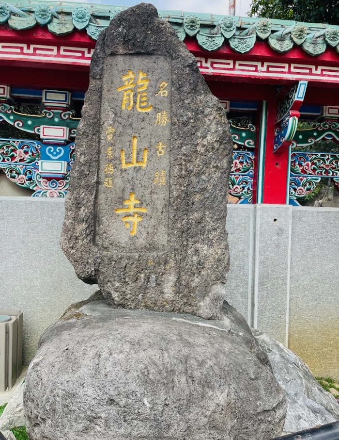 A rock with golden Chinese characters engraved in it near Longshan Temple in Taiwan
