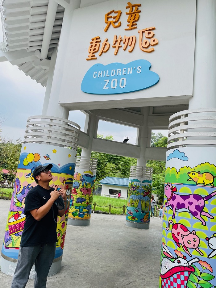 A man standing by a sign that read "Children's Zoo" at the Taipei Zoo in Taiwan 