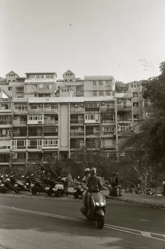 Two people riding a moped down the street of Beitou in Taiwan