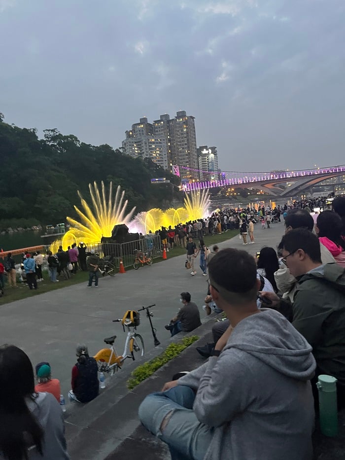 Many people gathered along the water for a water show in Xindian. 