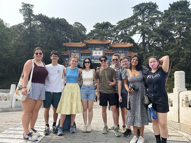 A group of nine CET Beijing students  visiting the Beijing Summer Palace and taking a photo in front of it