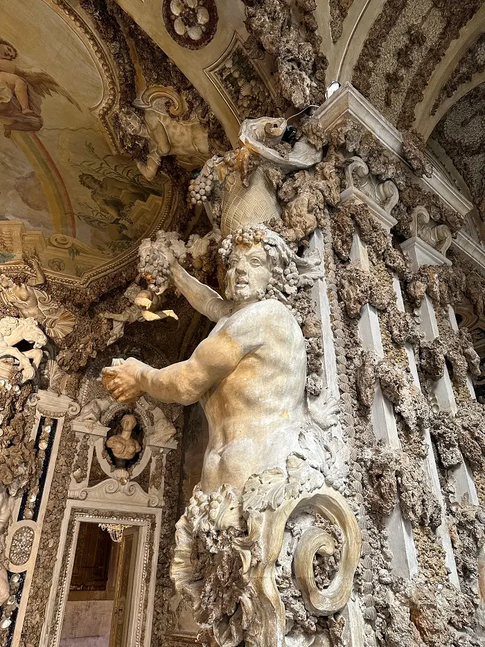 Intricate textures on the wall and the upper body of a man protruding from a column of Corsini Palace in Florence, Italy