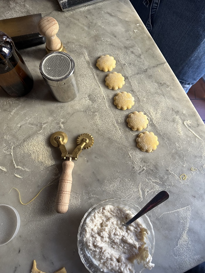 Five ravioli cut out with other pasta making tools and ingredients