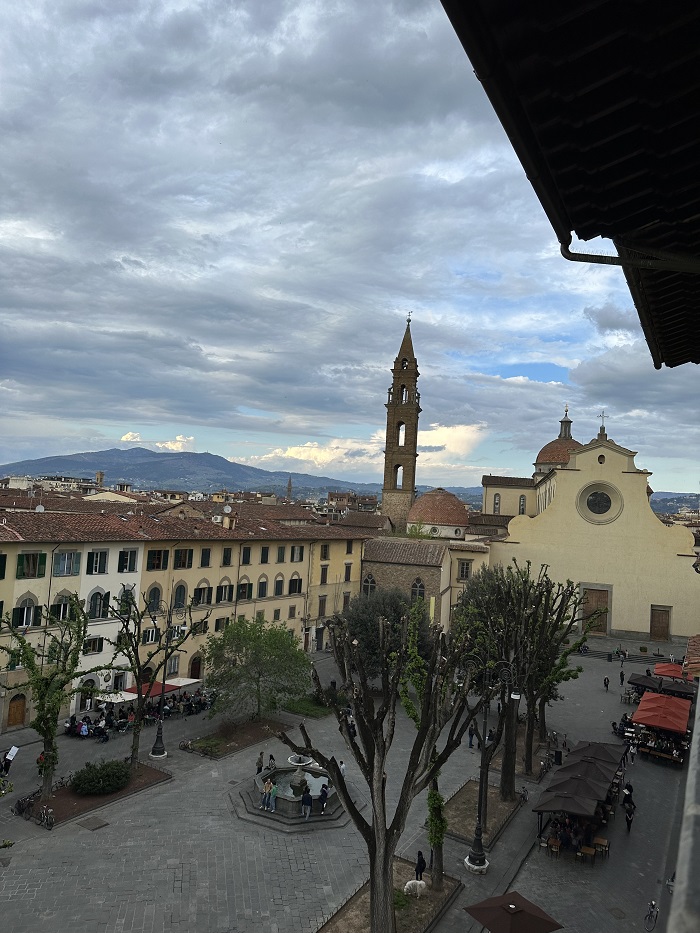 View of the Santo Spirito piazza and people in it from a rooftop bar in Florence