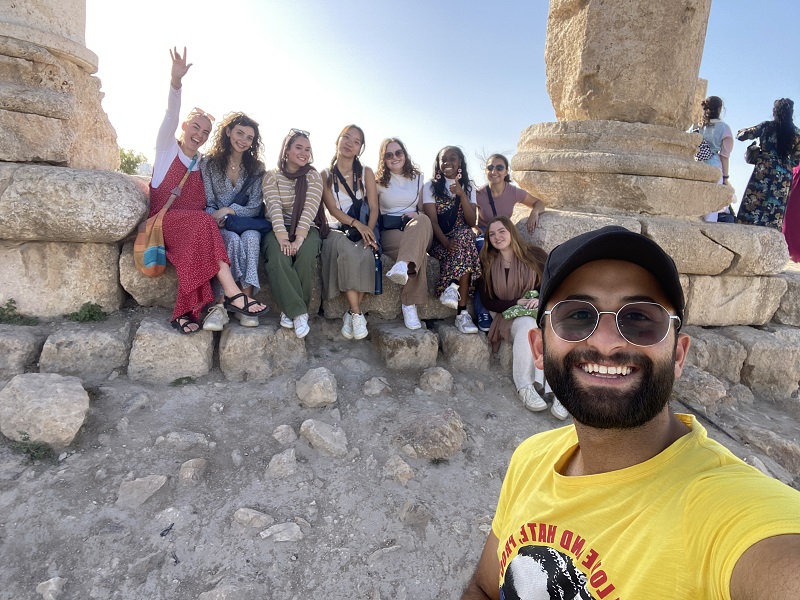 A Jordanian neighbor taking a selfie with some CET Jordan students at the bottom of the citadels 