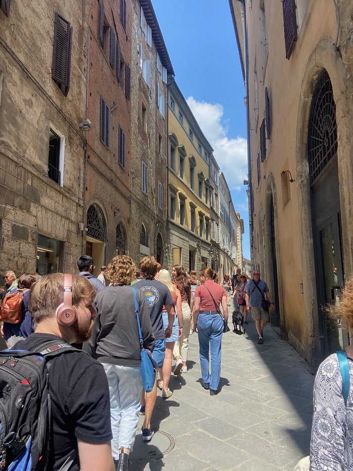 People walking in a narrow street in Siena, Italy
