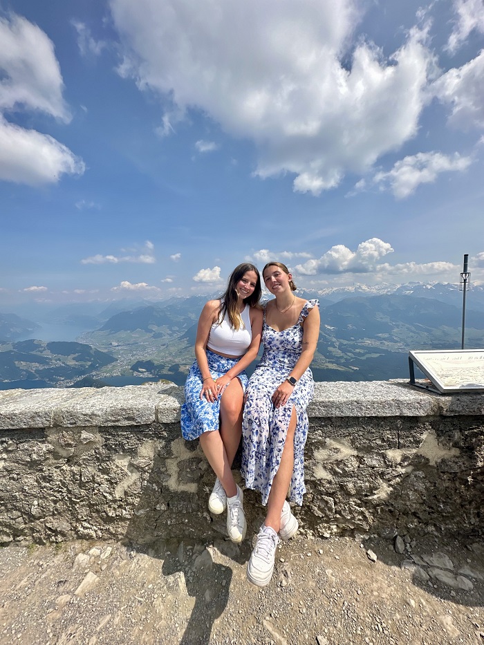 A CET Siena student and her roommate sitting on a ledge on the top of Mt. Pilatus in Lucerne, Switzerland