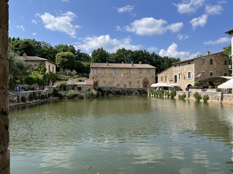 A empty hot spring within Bagno Vignoni in Italy on a partly cloudy day