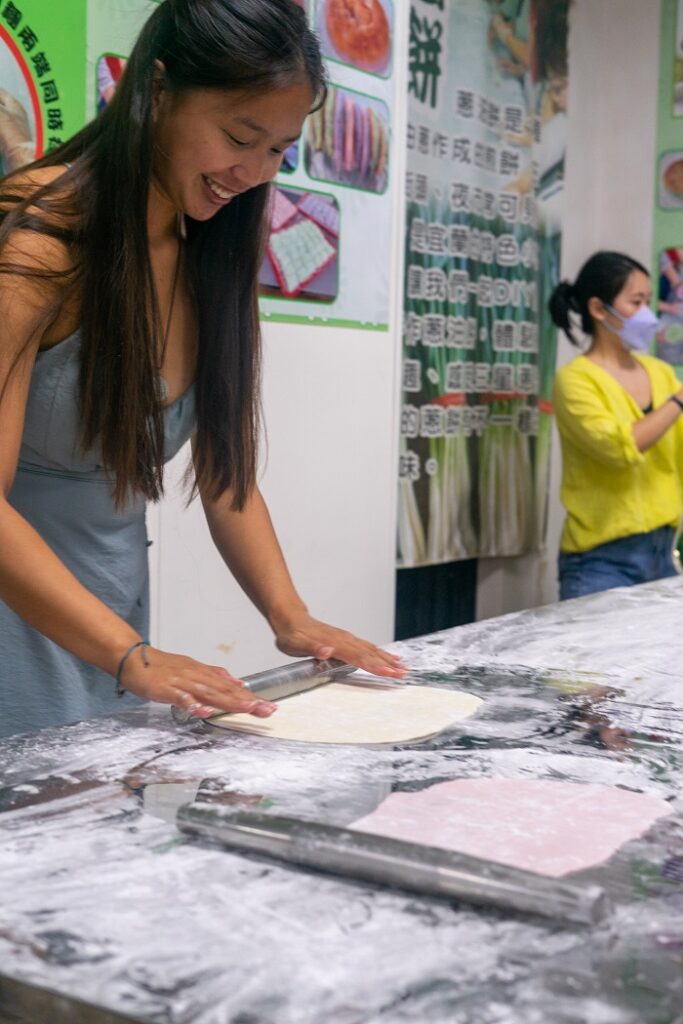 A CET Taiwan student rolling out dough during a scallion pancake cooking class