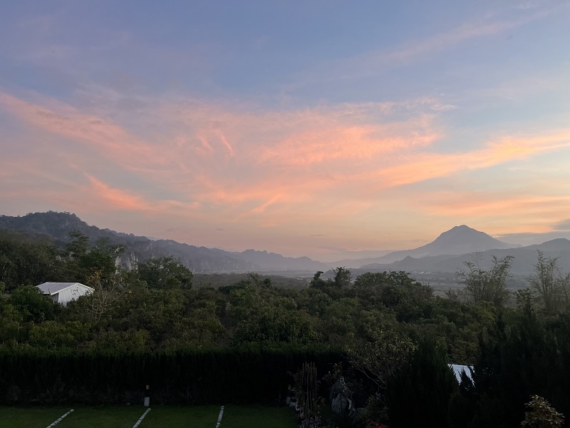 View of the sunrise above mountains and trees from an airbnb in Taitung