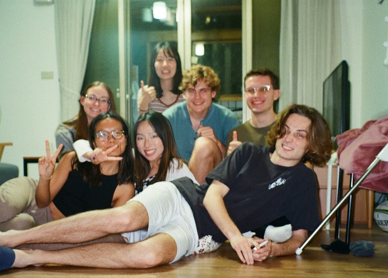 A group photo of CET Taiwan students sitting on the floor of an apartment