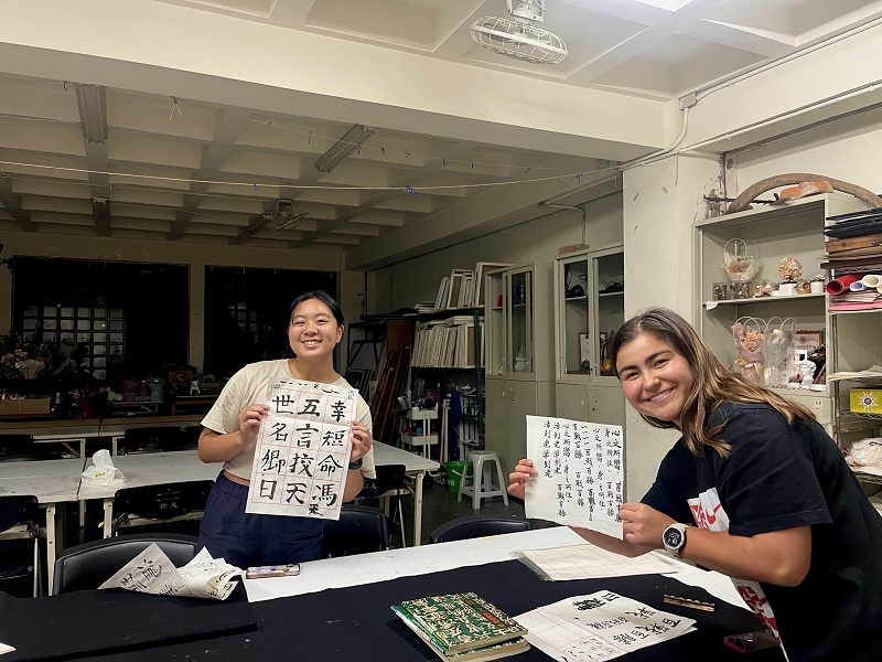A CET Taiwan student and her local roommate holding up their papers with calligraphy 