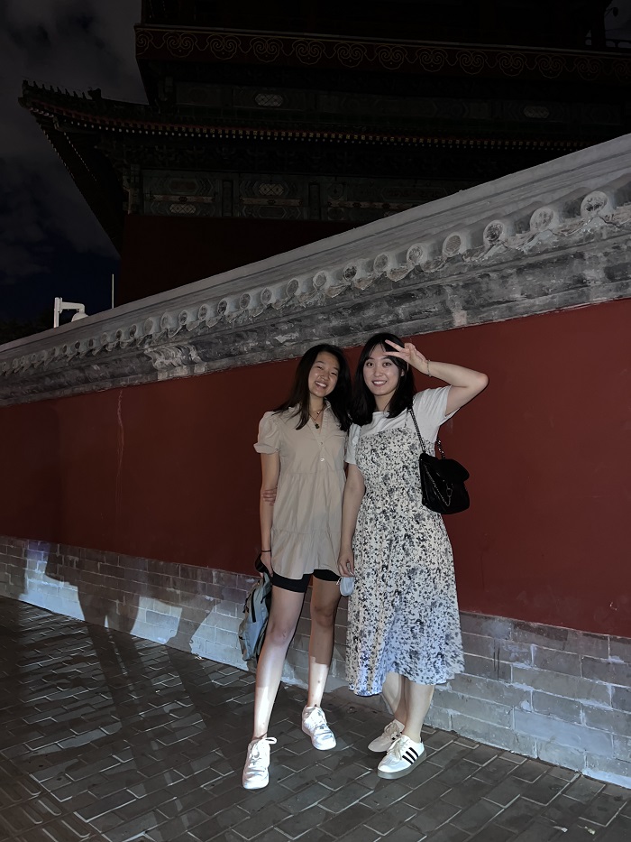 A CET Beijing student and her language partner standing in front of a wall outside 