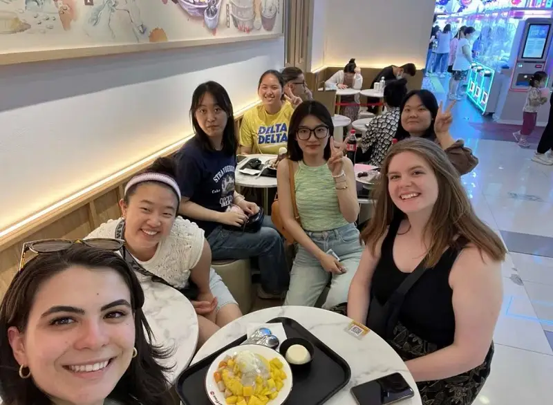 CET Beijing students and their language partners sitting around multiple tables indoors to share shaved ice