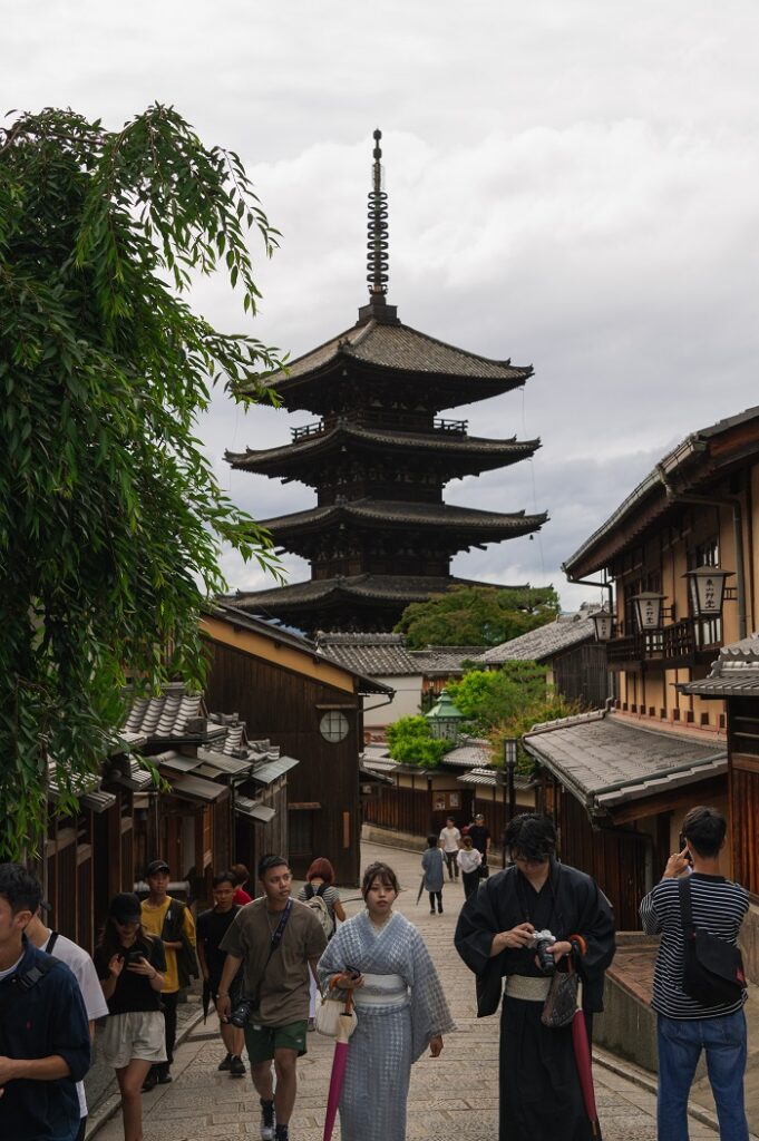 People walking up a street between buildings near Hokanji Temple in Japan