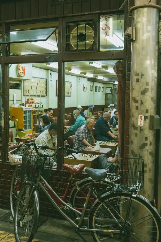 A view of people playing games through a window such as Igo and Syougi in Japan