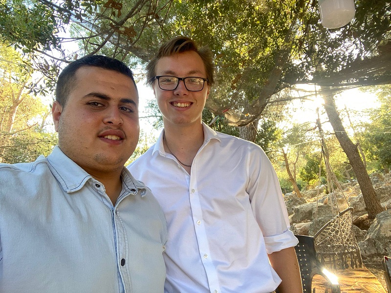 A male CET Jordan student alongside his local Jordanian language partner taking a selfie outside