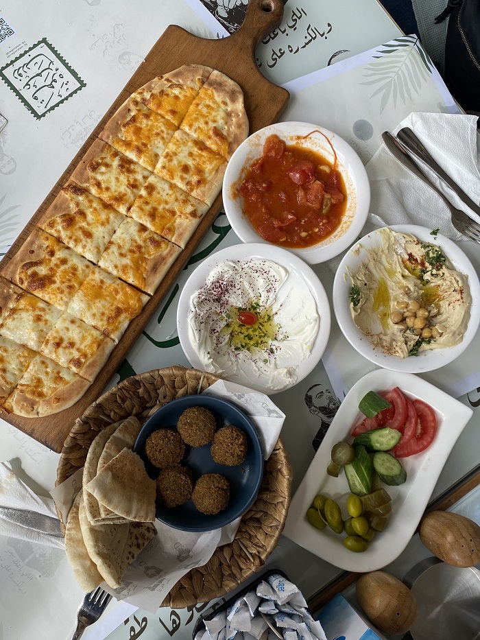 Falafel, flat bread, dips, and other vegetables displayed on a table