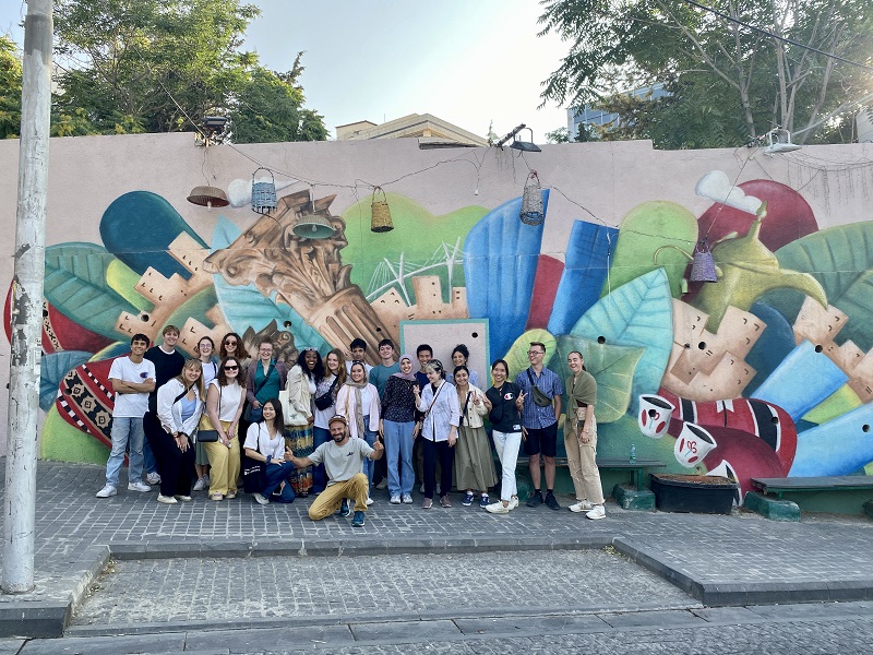 A large group of CET Jordan students in front of an outdoor mural