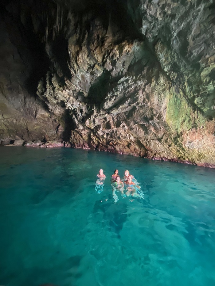 A group of five CET Siena students in blue waters within a cave at Amalfi Coast