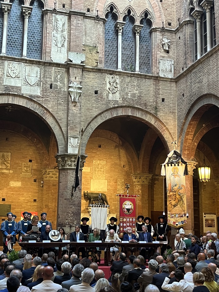 2023 Palio di Siena reveal ceremony with one of the silk banners bearing the image of the Virgin Mary with many witnesses of the crowd