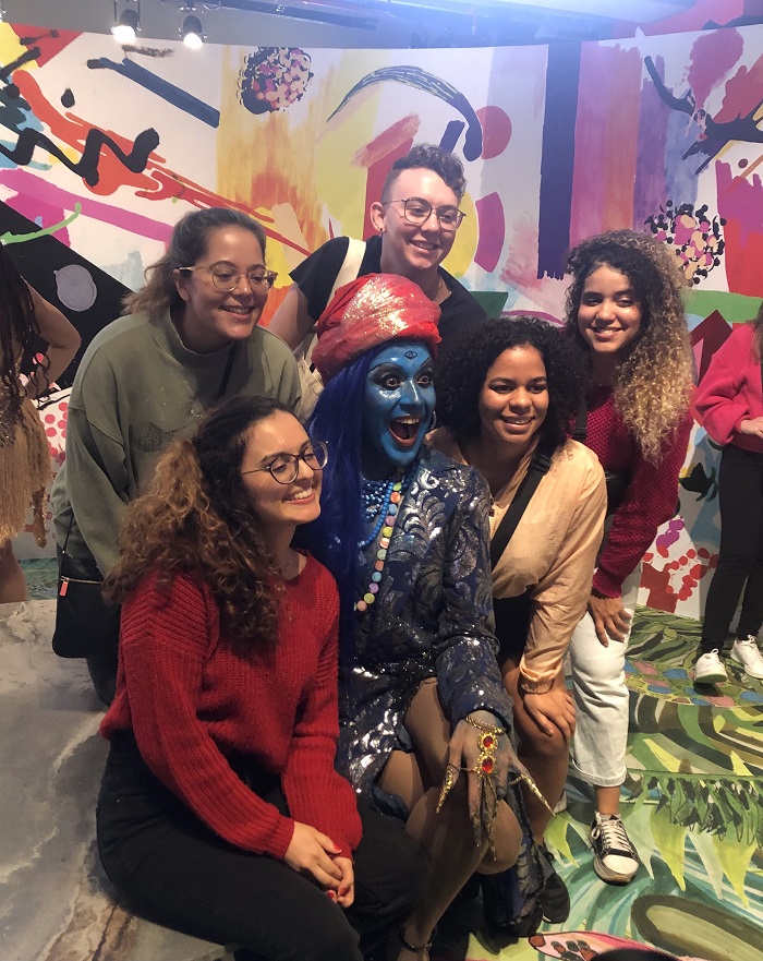 CET Brazil Social Justice students sitting and smiling around a person in an interactive performance exhibit