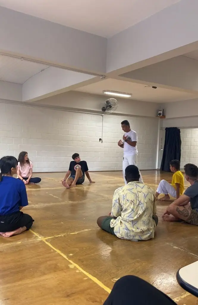 CET Brazil Social Justice students sitting on wooden floor in a Capoeira workshop hosted by Pontifícia Universidade Católica de São Paulo