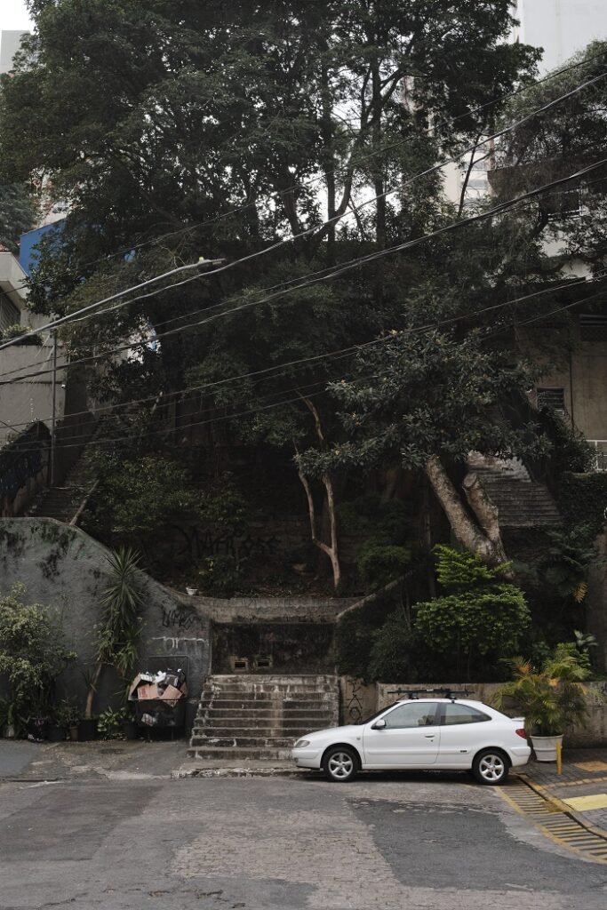 A street with a parked car and steep stairs in Brazil