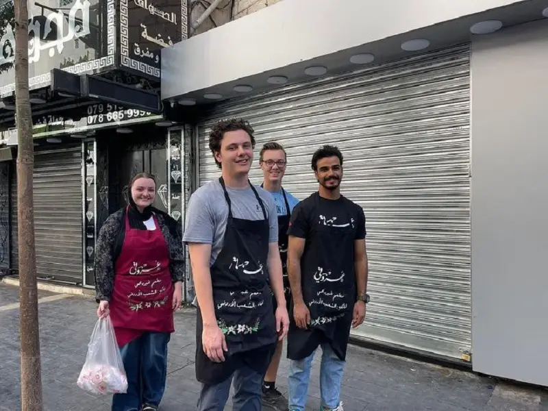 A CET Jordan student and other volunteers in downtown Amman passing out sandwiches