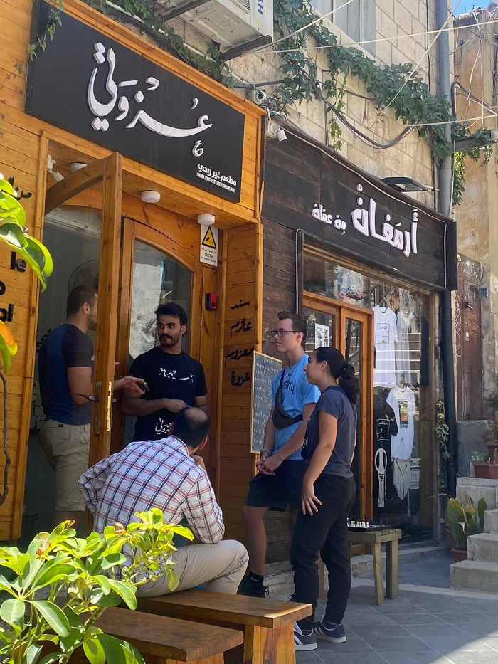 Volunteers standing outside by the door of the Ezwitti restaurant to receive instructions for the day