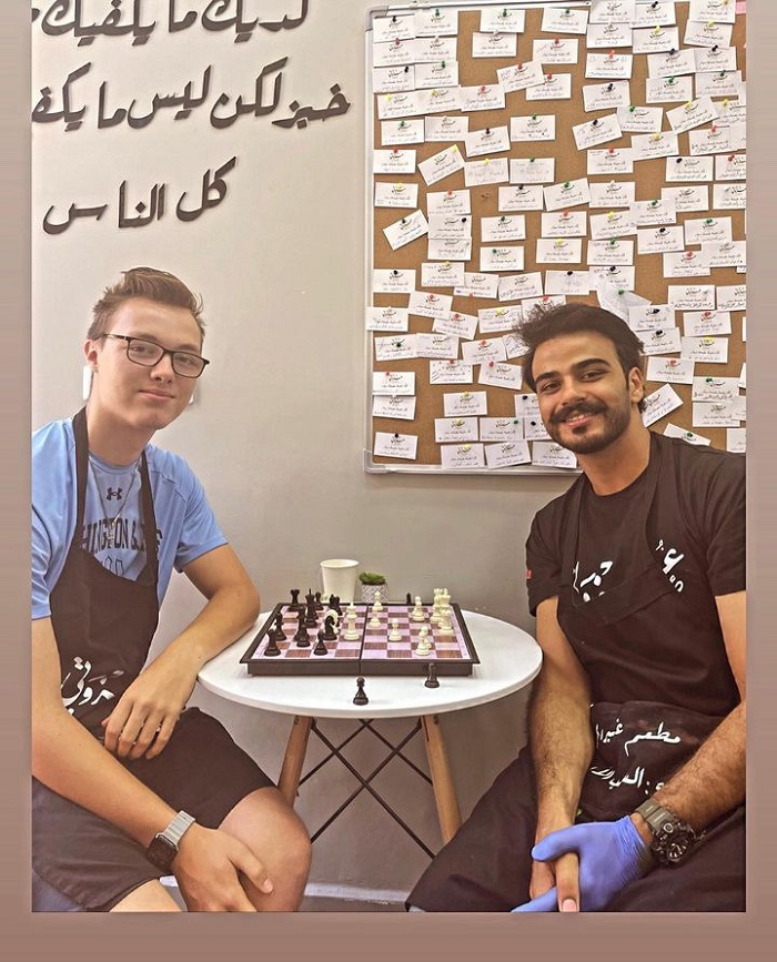 A CET Jordan male student and another volunteer playing chess