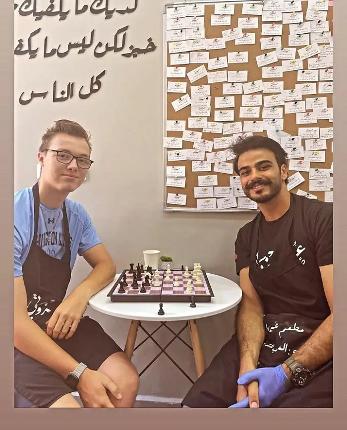 A CET Jordan male student and another volunteer playing chess