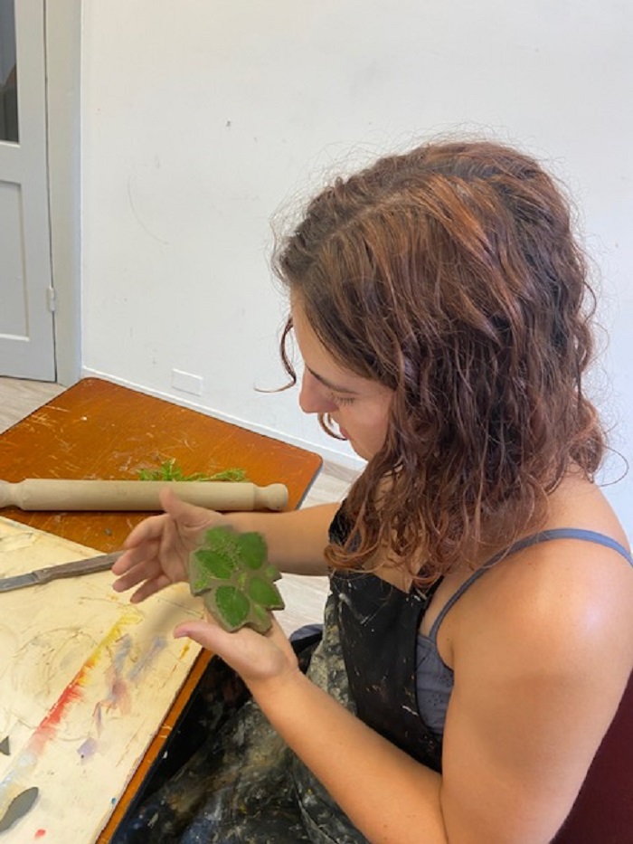 A CET Siena student working with plants and wet clay in a ceramics workshop 
