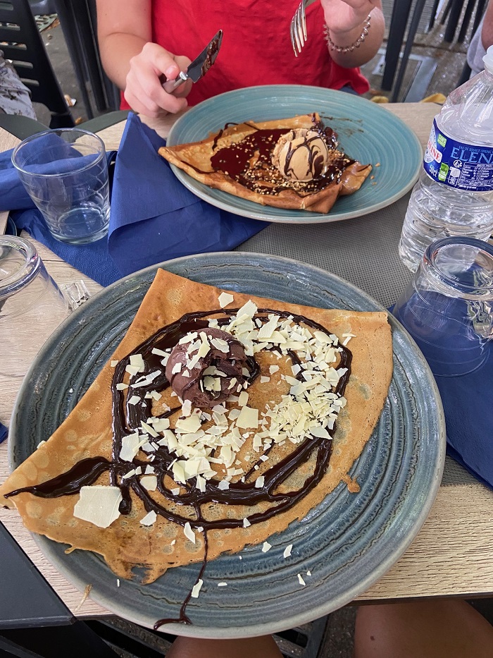 Crepes drizzled in chocolate on two plates 