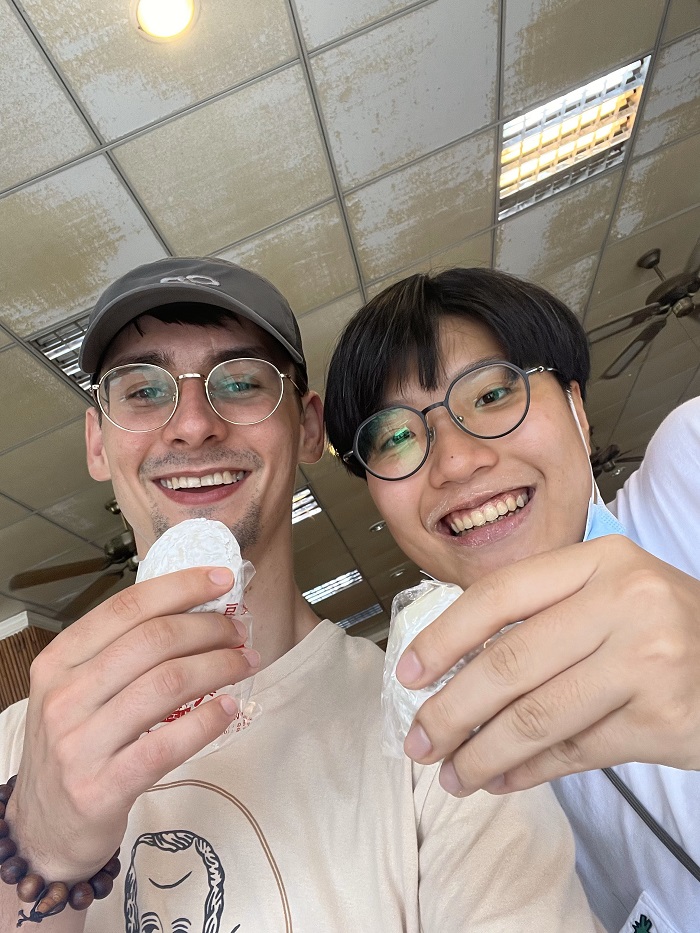 CET Taiwan student and his language partner, Hua, smiling and holding up a mochi ball