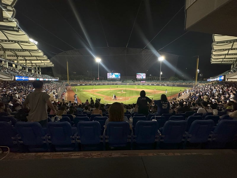 Wide view of the Fubon Guardians playing baseball on a field with fans watching at night