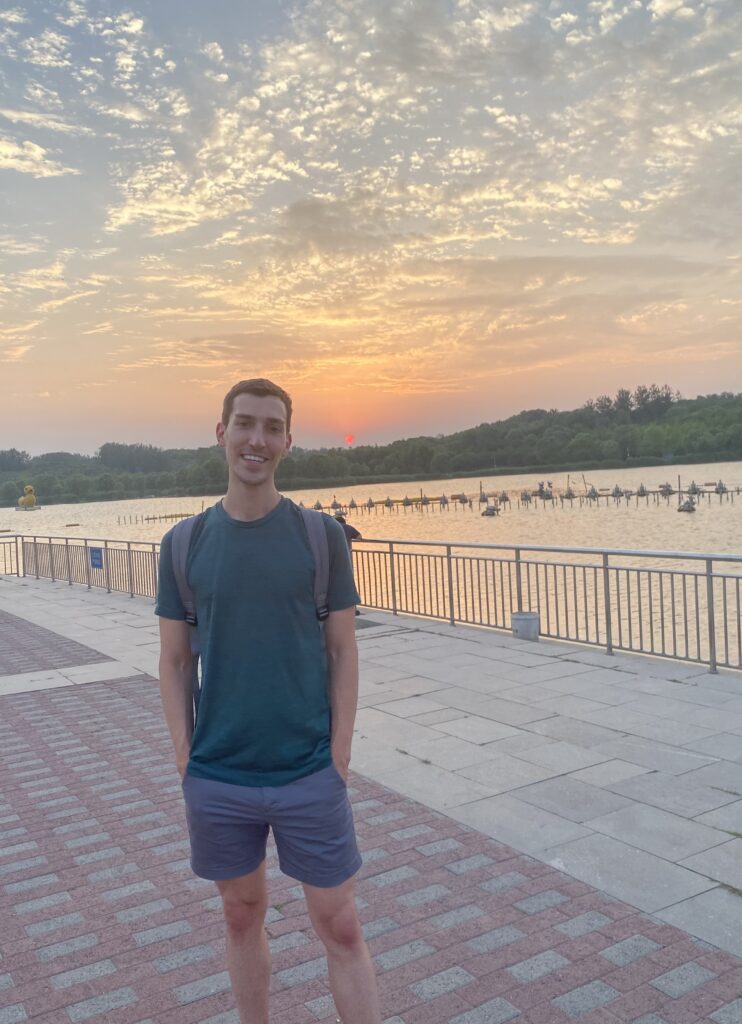 man smiling in front of sunset