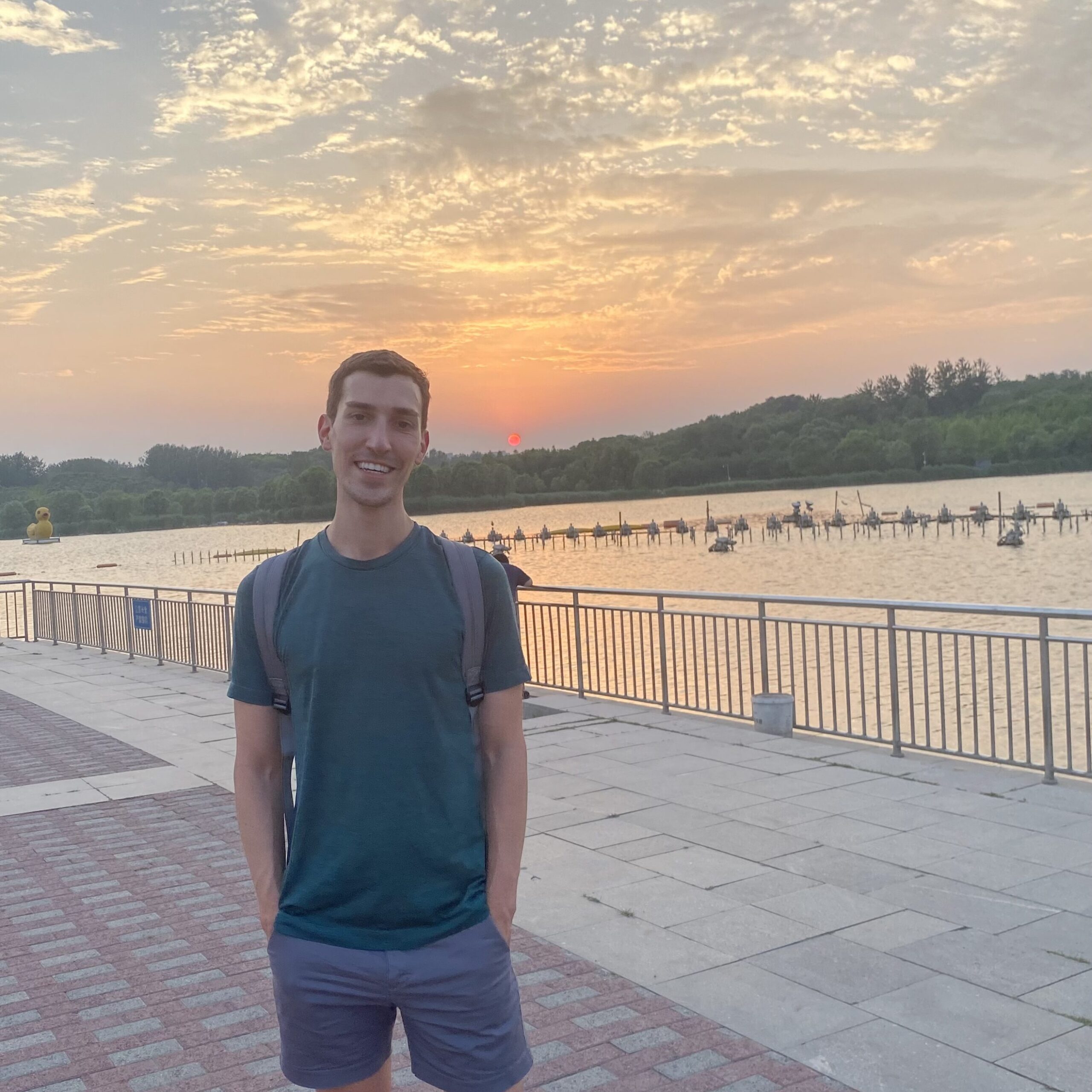Man smiling in front of sunset